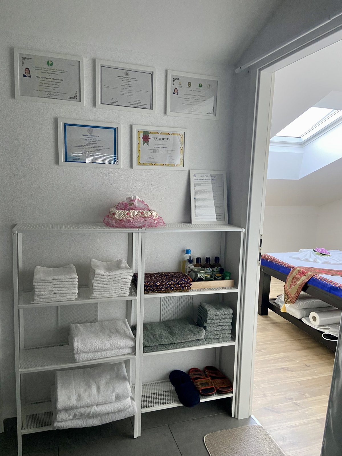 Mur des diplômes de Tukta affiché dans le couloir du salon Leela Thaï Massage à Massongex